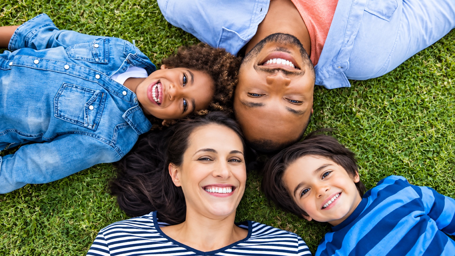 Famille allongée dans l'herbe devant sa maison rénovée
